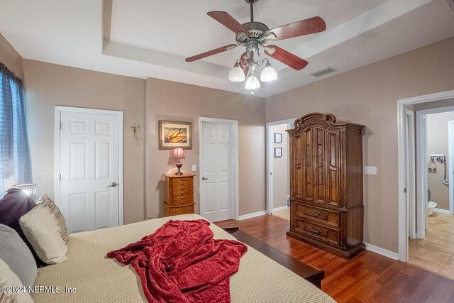 bedroom with wood-type flooring, ceiling fan, and ensuite bathroom