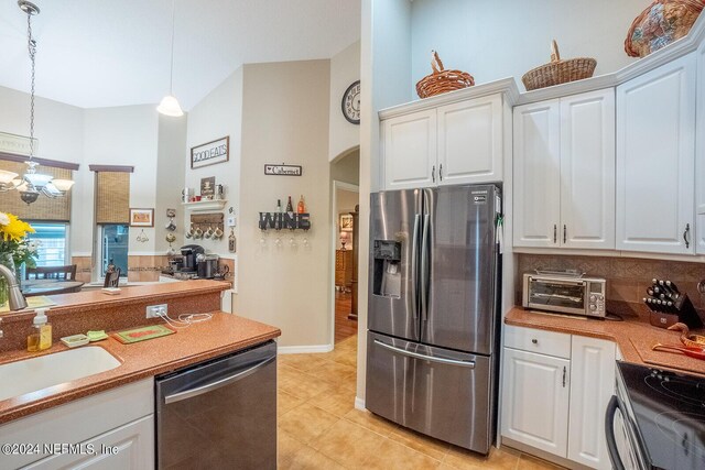 kitchen featuring white cabinetry, stainless steel appliances, an inviting chandelier, decorative light fixtures, and sink