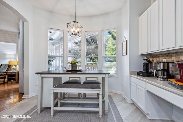 dining space featuring an inviting chandelier and light hardwood / wood-style flooring