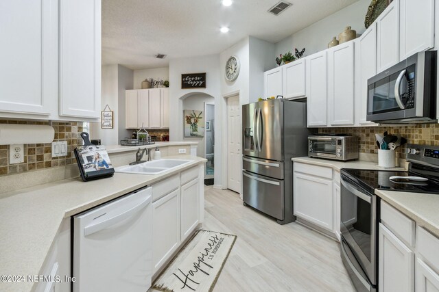 kitchen with light hardwood / wood-style flooring, stainless steel appliances, white cabinets, and sink