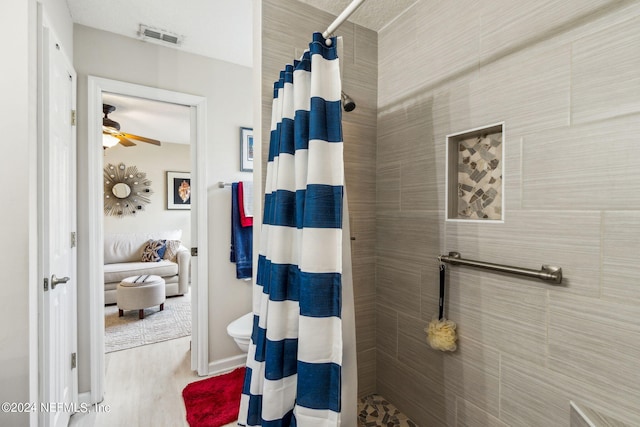 bathroom with wood-type flooring, ceiling fan, toilet, and curtained shower