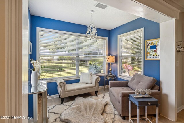 sitting room with an inviting chandelier and light hardwood / wood-style floors