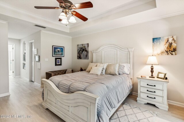 bedroom with ornamental molding, light hardwood / wood-style floors, and ceiling fan