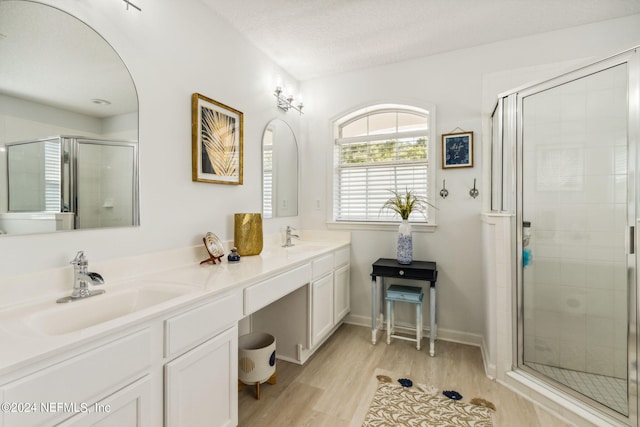 bathroom with a textured ceiling, a shower with door, vanity, and hardwood / wood-style flooring