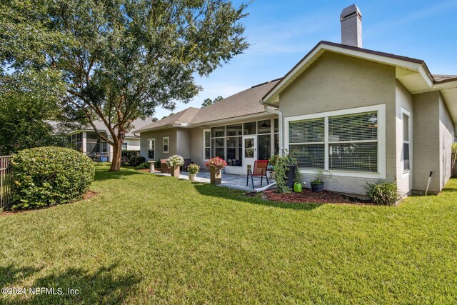 back of house featuring a patio and a yard