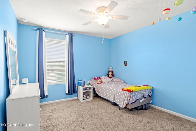 carpeted bedroom with a textured ceiling and ceiling fan