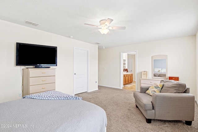 carpeted bedroom with a textured ceiling, ceiling fan, and ensuite bathroom