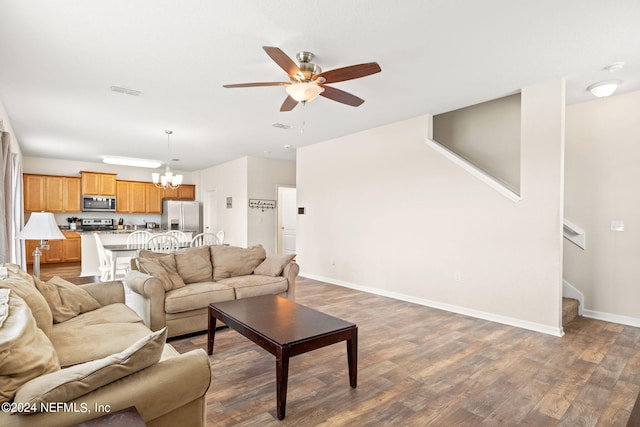 living room featuring dark wood-type flooring and ceiling fan with notable chandelier