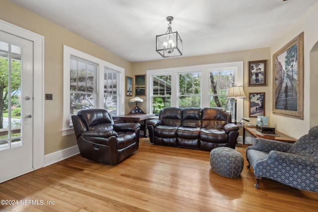 living room featuring a healthy amount of sunlight, light hardwood / wood-style floors, and a notable chandelier