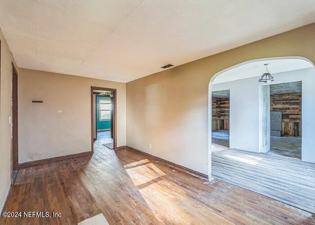 unfurnished room with a stone fireplace and hardwood / wood-style flooring