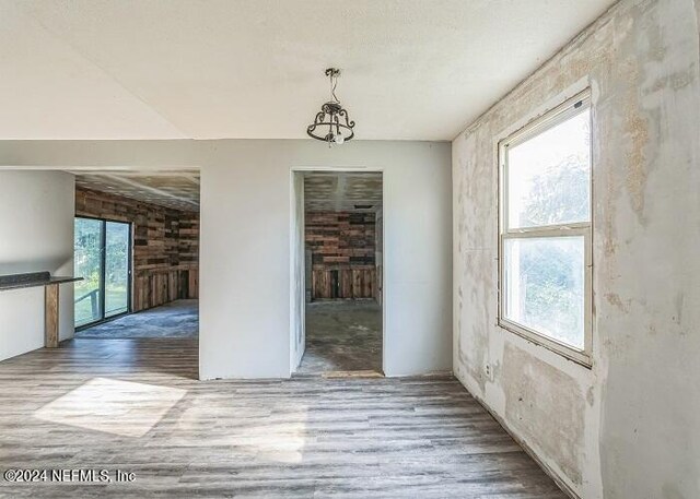 spare room with light hardwood / wood-style flooring and a chandelier