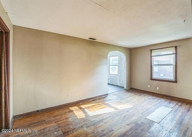 empty room featuring hardwood / wood-style flooring and a textured ceiling