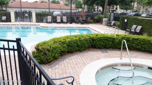 view of pool with a patio and a hot tub