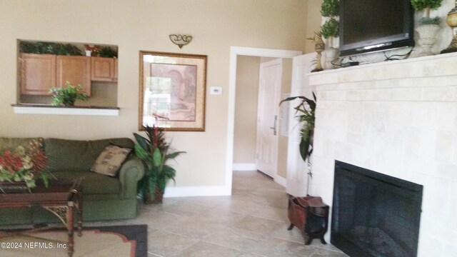 living room with a brick fireplace and light tile patterned floors