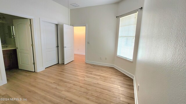 unfurnished bedroom featuring light hardwood / wood-style flooring and ensuite bath