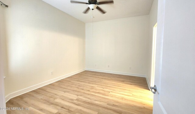 empty room with ceiling fan and light hardwood / wood-style flooring