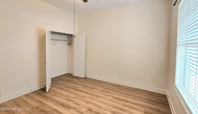 unfurnished bedroom featuring a closet and light hardwood / wood-style floors