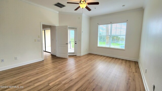 empty room with light hardwood / wood-style flooring, ornamental molding, ceiling fan, and a healthy amount of sunlight