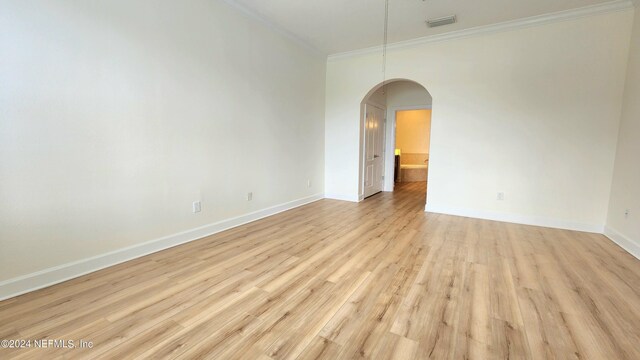 empty room featuring ornamental molding and light hardwood / wood-style floors