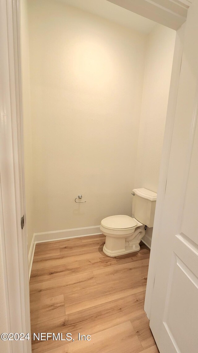 bathroom featuring wood-type flooring and toilet