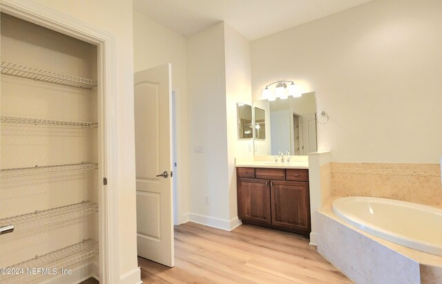 bathroom featuring vanity, hardwood / wood-style floors, and a tub