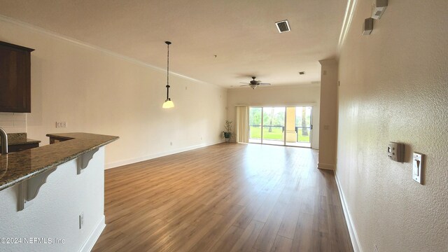 living room with wood-type flooring, ceiling fan, and crown molding