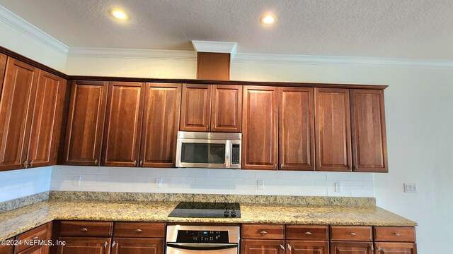 kitchen featuring light stone counters, tasteful backsplash, a textured ceiling, appliances with stainless steel finishes, and crown molding