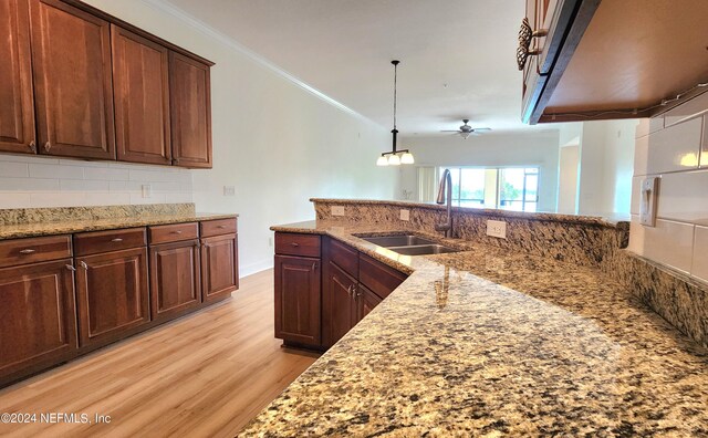 kitchen featuring pendant lighting, light hardwood / wood-style floors, sink, crown molding, and ceiling fan