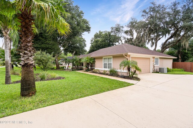 view of front of house featuring central AC, a front yard, and a garage