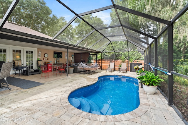 view of pool with a patio, an outdoor living space, and a lanai