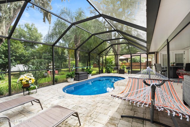 view of pool featuring a patio and glass enclosure