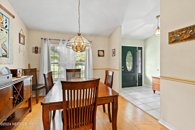 dining area featuring light hardwood / wood-style flooring and a chandelier