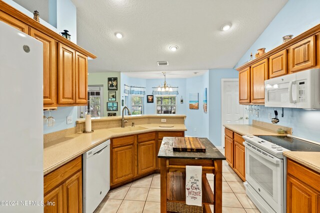 kitchen featuring light tile patterned floors, a textured ceiling, sink, and white appliances