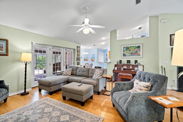 living room with light wood-type flooring, vaulted ceiling, and ceiling fan