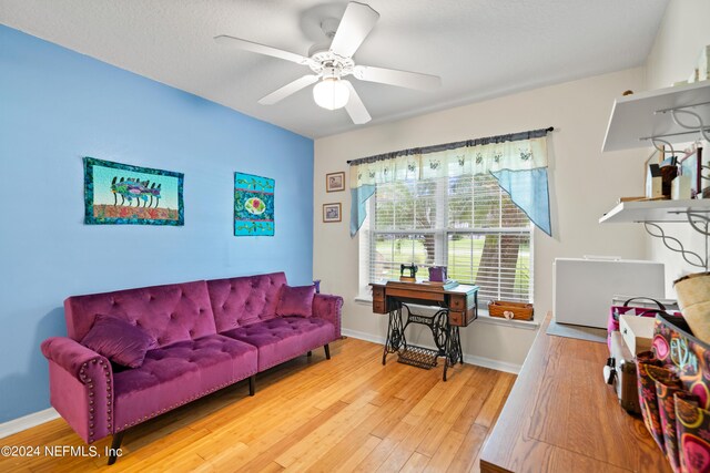 living room with wood-type flooring and ceiling fan