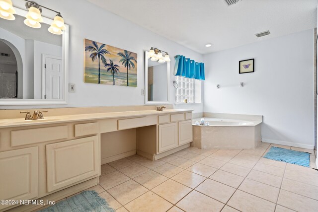 bathroom featuring tile patterned floors, tiled bath, and vanity