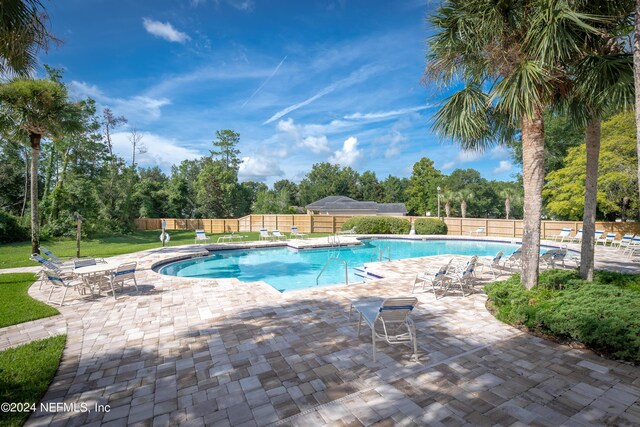 view of swimming pool with a patio and a yard