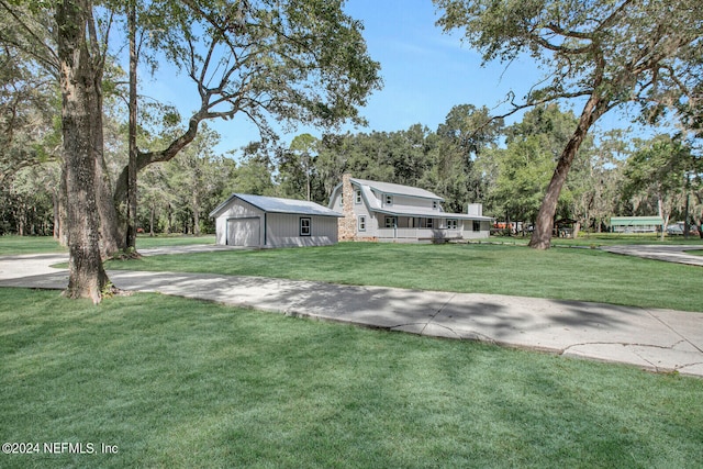 view of front of house with a front lawn, an outdoor structure, and a garage