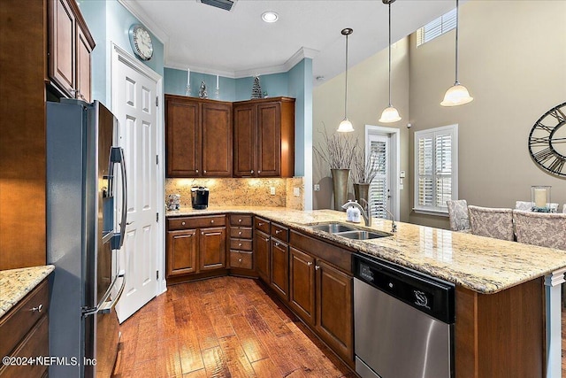 kitchen featuring dark wood-type flooring, sink, appliances with stainless steel finishes, decorative light fixtures, and crown molding