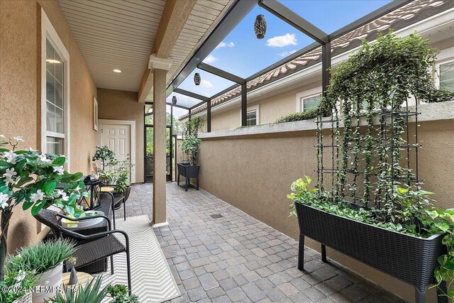 view of patio featuring a lanai