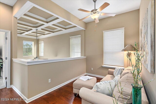 living area with coffered ceiling, beamed ceiling, ceiling fan, ornamental molding, and dark hardwood / wood-style floors