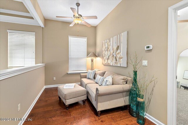 sitting room with ceiling fan and dark wood-type flooring