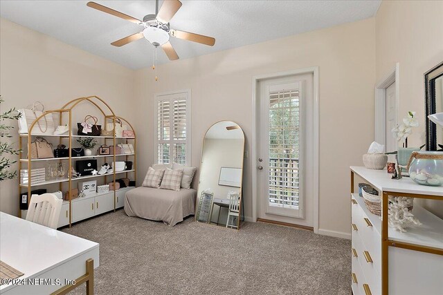 carpeted bedroom with ceiling fan, access to exterior, and a textured ceiling