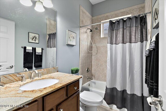 full bathroom with shower / tub combo with curtain, vanity, and toilet