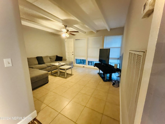 living room with ceiling fan, light tile patterned floors, and beam ceiling