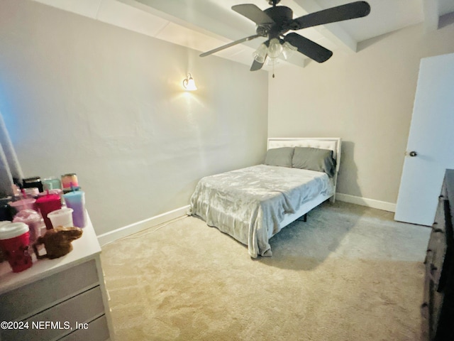 carpeted bedroom featuring beam ceiling and ceiling fan