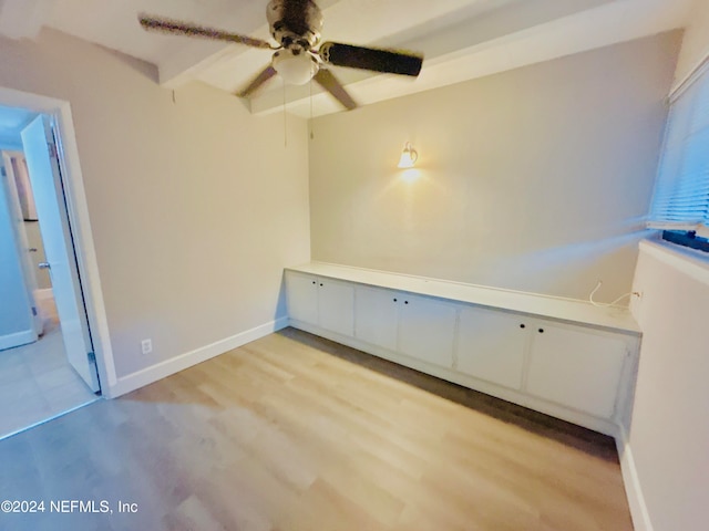 spare room with beam ceiling, ceiling fan, and light hardwood / wood-style floors