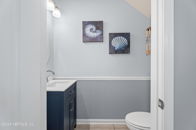 bathroom featuring tile patterned floors, vaulted ceiling, vanity, and toilet