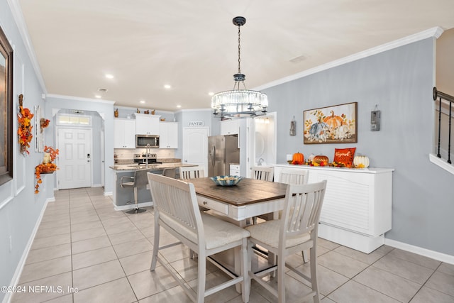 tiled dining space featuring a notable chandelier and crown molding