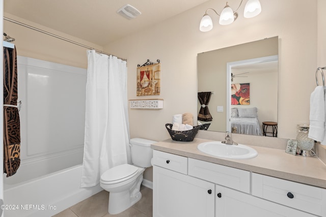 full bathroom featuring shower / bath combo with shower curtain, tile patterned floors, vanity, and toilet